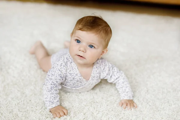 Little funny baby girl lifting body and learning to crawl. — Stock Photo, Image