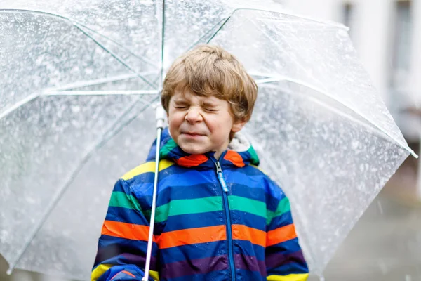 Petit garçon blond sur le chemin de l'école marchant pendant la neige fondue, la pluie et la neige avec un parapluie par temps froid — Photo