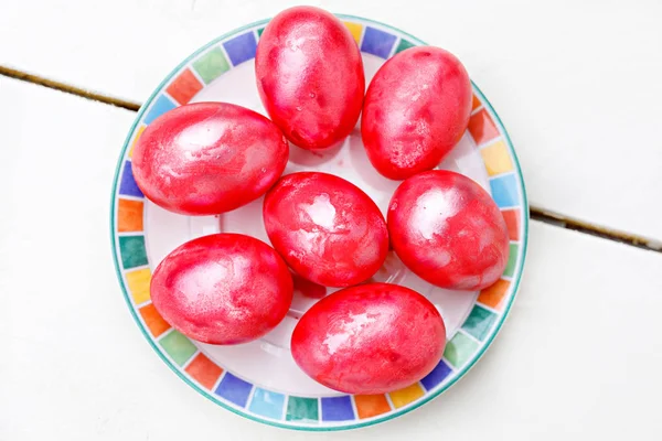 Ostereier auf Holzgrund. bunte Eier in verschiedenen Farben - rot, gelb, orange, lila und grün. — Stockfoto