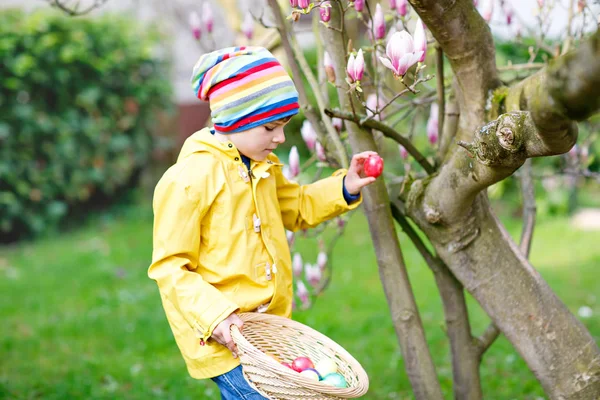 Schattige schattige kleine jongen jongen maken een ei jagen op Pasen. — Stockfoto