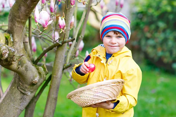 Bonito menino adorável fazendo uma caça ao ovo na Páscoa . — Fotografia de Stock