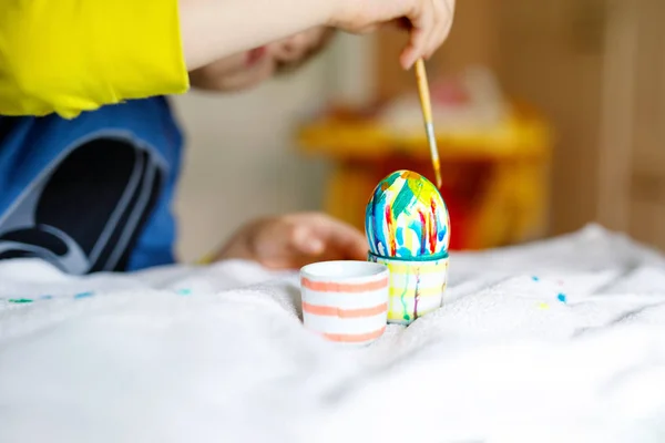 Close-up of little kid hands coloring eggs for Easter holiday — Stock Photo, Image