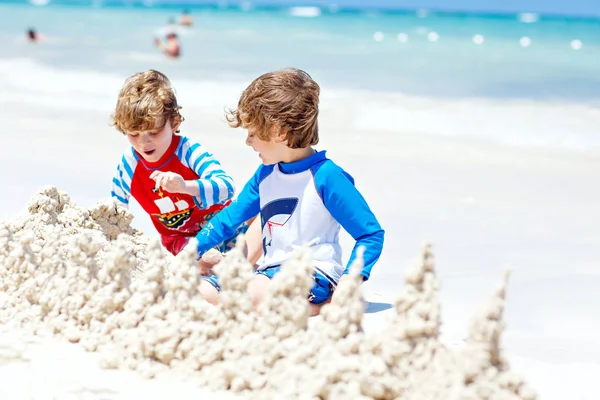 Twee jongen jongens bouwen van zandkasteel op tropisch strand van Malediven — Stockfoto