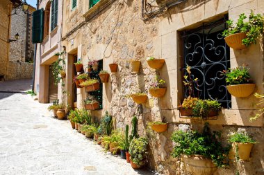 Beautiful street in Valldemossa with traditional flower decoration, famous old mediterranean village of Majorca. Balearic island Mallorca, Spain clipart