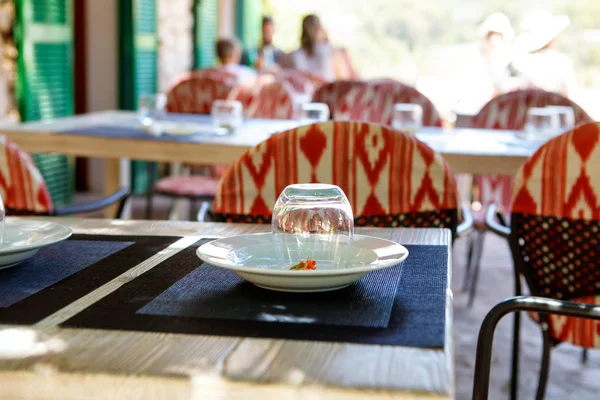 Café al aire libre, mesa puesta para un luncho en un día soleado y cálido. Ciudad o pueblo mediterráneo — Foto de Stock