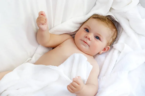 Lindo bebé jugando con sus propios pies después de tomar el baño. Adorable hermosa chica envuelta en toallas blancas —  Fotos de Stock