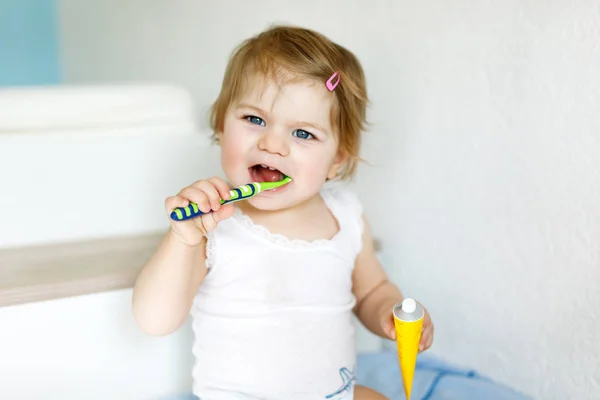 小女孩拿着牙刷,刷牙.幼儿学习清洁乳牙. — 图库照片
