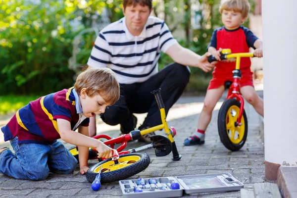 Két boldog kis gyerek fiú és apa lánc a kerékpárok javítása és a változás egyensúly Kerékpár kerék — Stock Fotó