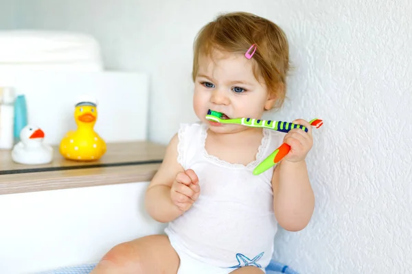 Petite fille tenant une brosse à dents et se brossant les premières dents. Enfant apprenant à nettoyer la dent de lait. — Photo