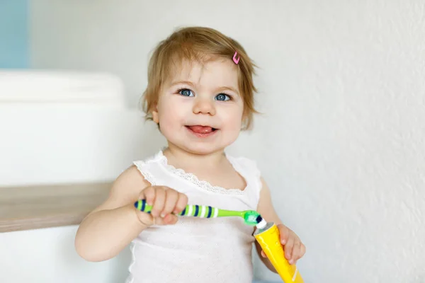 Κοριτσάκι που κρατάει οδοντόβουρτσα και βουρτσίζει τα πρώτα δόντια. Παιδί μαθαίνουν να καθαρίζουν τα δόντια του γάλακτος. — Φωτογραφία Αρχείου