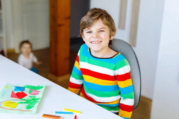 Kleiner Junge macht Papier Origami-Tulpenblumen für eine Postkarte zum Muttertag oder Geburtstag mit Baby Schwester Kleinkind auf dem Hintergrund — Stockfoto