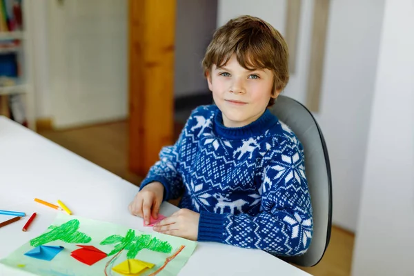 Kleine jongen maken papier origami tulp bloemen voor een ansichtkaart voor moeders dag of verjaardag. Schattig kind van de lagere school die handwerk doet — Stockfoto