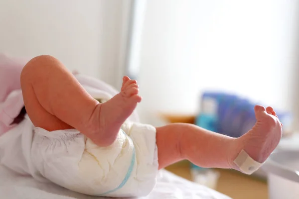 Feet of Newborn baby child seconds and minutes after birth lying on towel — Stock Photo, Image