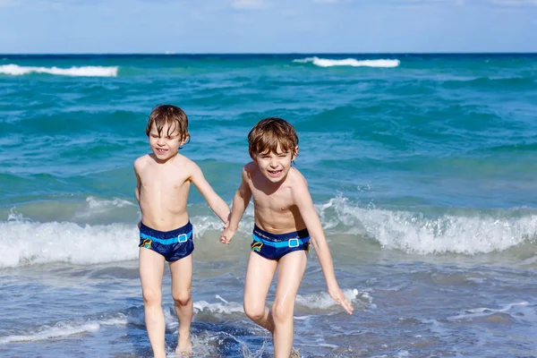Dwóch chłopców dziecko uruchomiona na ocean plaża. Drogie dzieci, zabawy — Zdjęcie stockowe