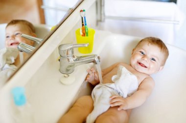 Alarak şirin bebek yıkama lavabo banyo ve musluk suyu yakala.