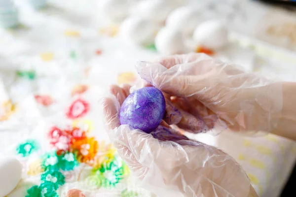 Nahaufnahme erwachsener Hände beim Färben von Ostereiern mit Farben — Stockfoto