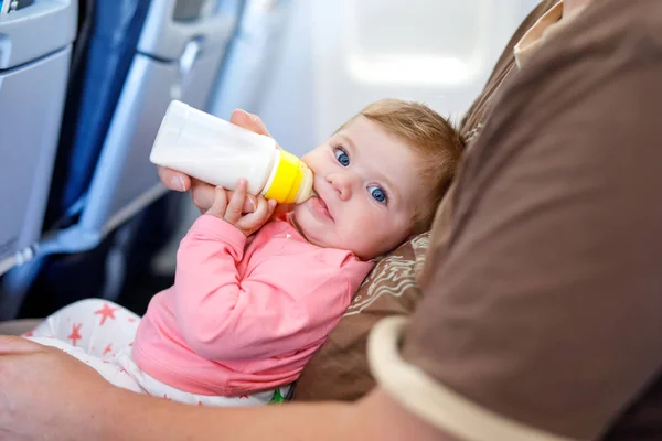 Vader zijn baby dochter houden tijdens de vlucht op het vliegtuig op vakantie te gaan — Stockfoto