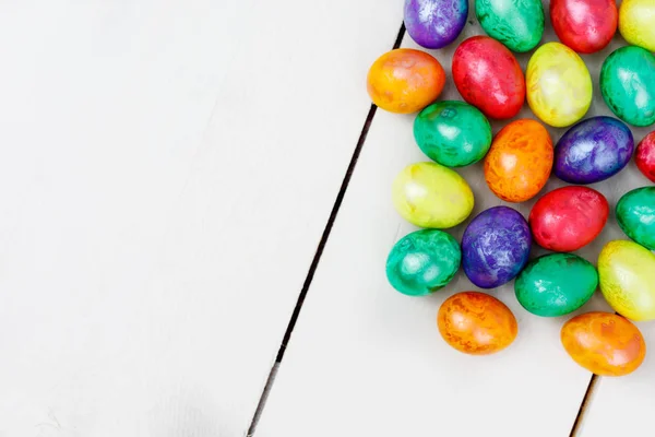 Huevos de Pascua sobre fondo de madera. Huevos coloridos en diferentes colores: rojo, amarillo, naranja, púrpura y verde . — Foto de Stock