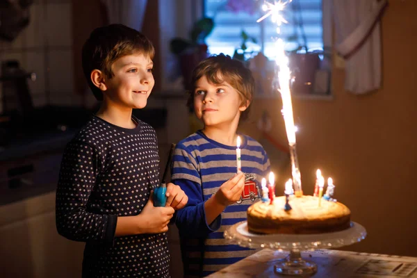 Doi copii frumoși, băieți preșcolari care sărbătoresc ziua de naștere și suflă lumânări — Fotografie, imagine de stoc