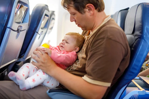 Isä pitelee tytärtään lentokoneessa lomalla. — kuvapankkivalokuva