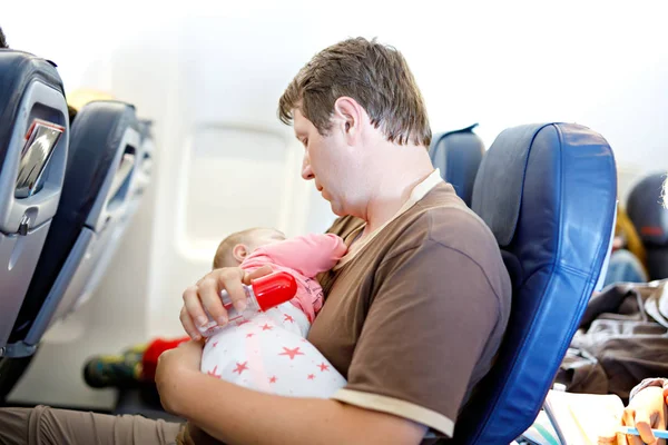 Young moe vader en dochter baby slapen tijdens de vlucht op het vliegtuig op vakantie te gaan — Stockfoto