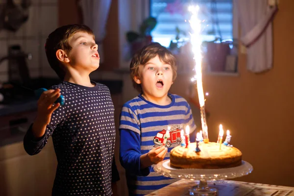 Két gyönyörű gyerek, iskoláskor előtti kisfiú ünnepli születésnapját, és fúj a gyertyák — Stock Fotó