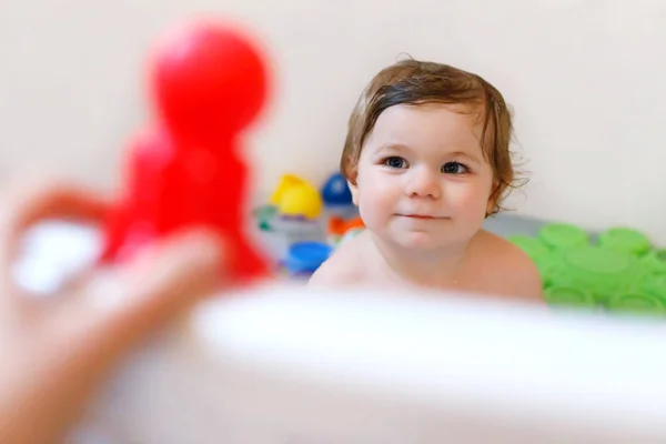 Carino adorabile bambina che fa il bagno schiumoso nella vasca da bagno. Bambino che gioca con i giocattoli in gomma da bagno. — Foto Stock