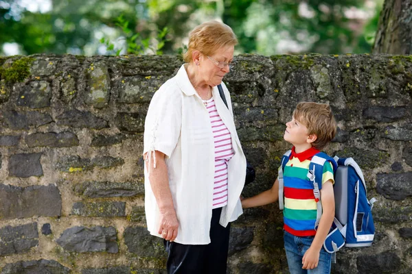 Grandmother taking child, kid boy to school on his first day — Stock Photo, Image