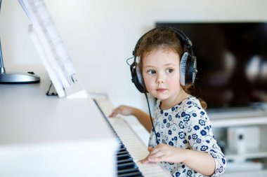 Güzel küçük çocuk kız oturma odası veya müzik okulu piyano
