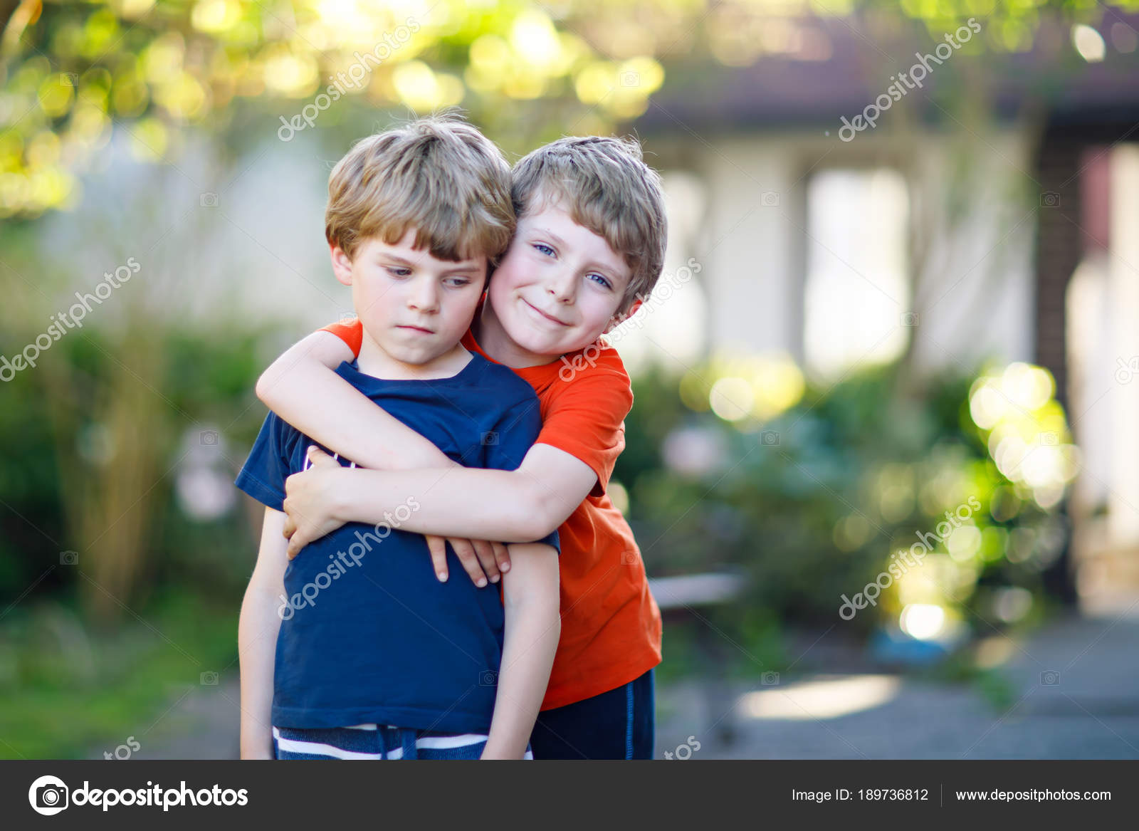 Two little active school kids boys, twins and siblings hugging on summer  day Stock Photo by ©romrodinka 189736812