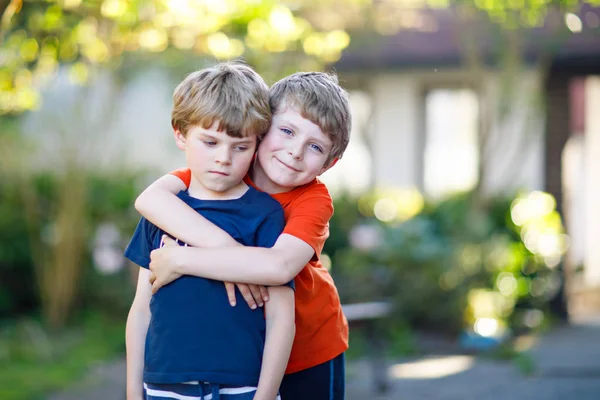 Dos niños de escuela activa, gemelos y hermanos abrazándose en el día de verano —  Fotos de Stock