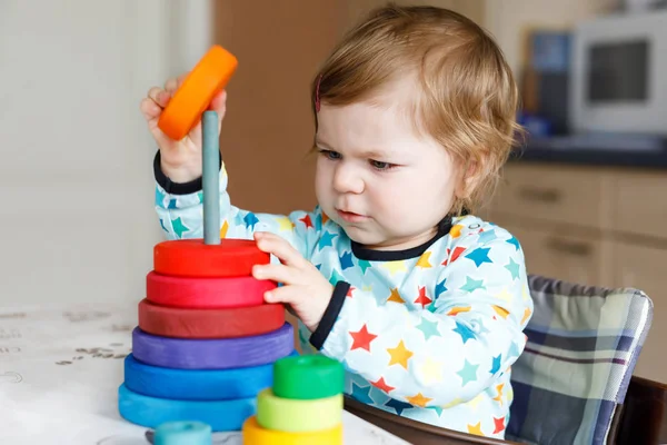 Entzückend niedlich schöne kleine Mädchen spielen mit pädagogischen Holz-Regenbogen-Spielzeug-Pyramide — Stockfoto