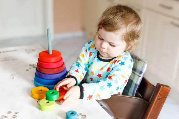 Entzückend niedlich schöne kleine Mädchen spielen mit pädagogischen Holz-Regenbogen-Spielzeug-Pyramide — Stockfoto