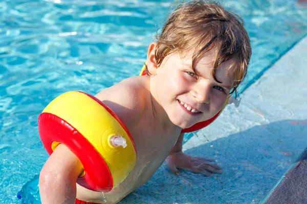 Menino feliz se divertindo em uma piscina — Fotografia de Stock