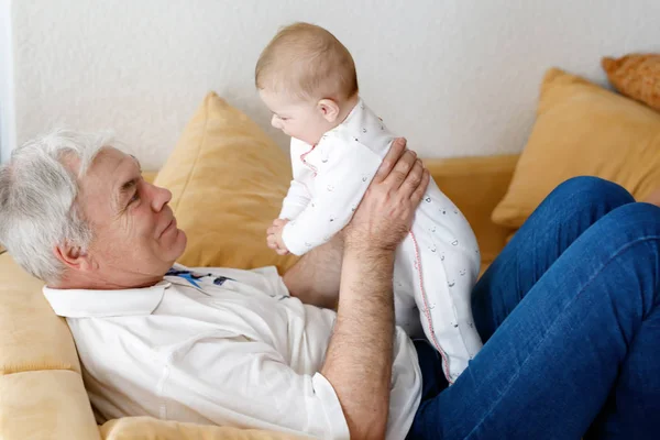 Avô feliz segurando bebê adorável neto menina nos braços . — Fotografia de Stock