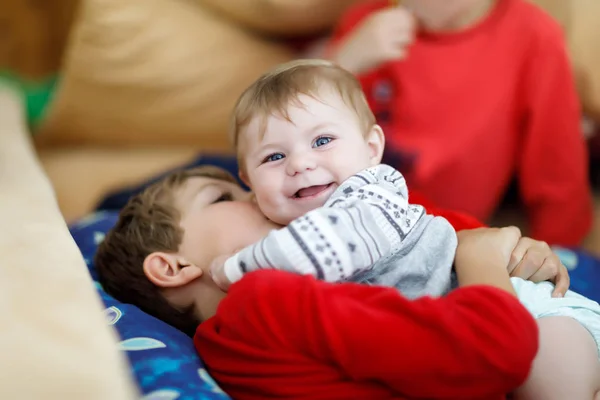 Little kid boy hugging with newborn baby girl, cute sister. Brother on background — Stock Photo, Image