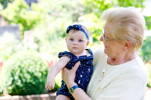 Schattig klein babymeisje met grootmoeder op zomerdag in de tuin — Stockfoto