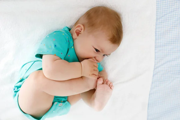 Bebê bonito tomando pés na boca. Adorável pequena menina chupando pé . — Fotografia de Stock