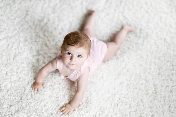 Little funny baby girl lifting body and learning to crawl. — Stock Photo, Image