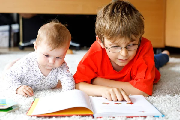 Baby girl and school kid boy reading books at home. — Stock Photo, Image