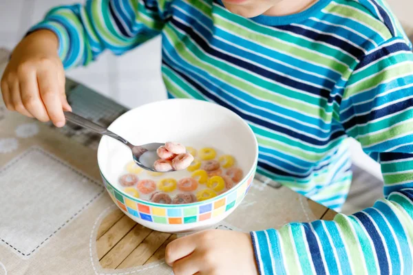 Niño de escuela rubio comiendo cereales con leche y bayas, fresa fresca para el desayuno —  Fotos de Stock