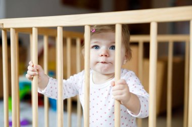 Güzel küçük bebek kız çocuk parkı içinde ayakta. Renkli oyuncakla oynamak sevimli sevimli çocuk