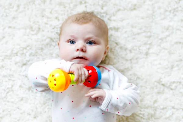 Cute baby girl gry z kolorowe grzechotka zabawki — Zdjęcie stockowe