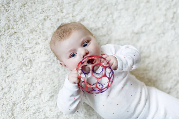 Roztomilé dítě dívka hrát s barevným chrastítko hračka — Stock fotografie