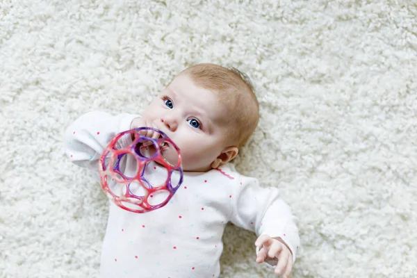 Söt liten flicka leker med färgglada skallra leksak — Stockfoto