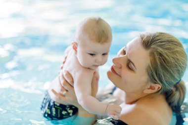 Mutlu orta yaşlı anne ile şirin Bebek Yüzme havuzunda Yüzme.