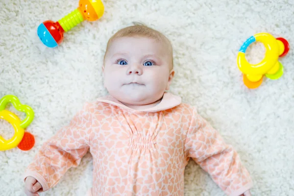 Cute baby girl gry z kolorowe grzechotka zabawki — Zdjęcie stockowe