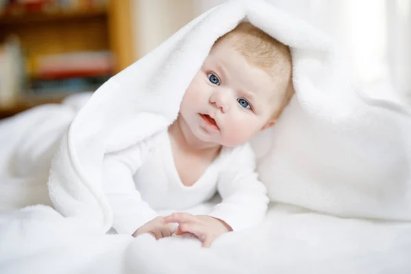 Menina bebê vestindo toalha branca ou overal de inverno no quarto ensolarado branco — Fotografia de Stock