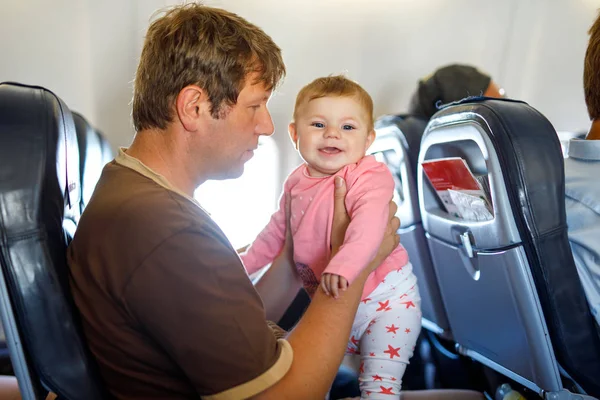 Joven padre cansado y su hija llorando durante el vuelo en avión de vacaciones — Foto de Stock