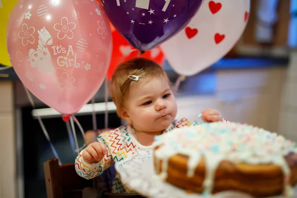 可爱的小女孩庆祝第一个生日。婴孩吃 marshmellows 装饰在自制的蛋糕, 室内. — 图库照片